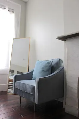 a couch sitting in a living room with a mirror at CHIC, Renovated Brownstone in PRIME DT Albany in Albany