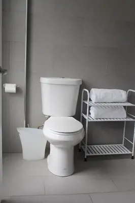 a white toilet in a bathroom with towels at CHIC, Renovated Brownstone in PRIME DT Albany in Albany