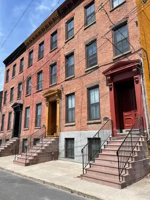a red brick building with stairs in front of it at CHIC, Renovated Brownstone in PRIME DT Albany in Albany
