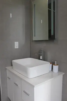 a bathroom with a white sink and a mirror at CHIC, Renovated Brownstone in PRIME DT Albany in Albany