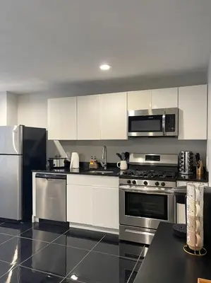 a kitchen with white cabinets and stainless steel appliances at MODERN 1BR Apt with PRIVATE deck in Albany