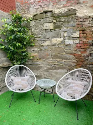 two white chairs and a table in front of a stone wall at MODERN 1BR Apt with PRIVATE deck in Albany
