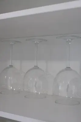four wine glasses sitting on top of a shelf at MODERN 1BR GREAT Location Downtown Parking in Albany