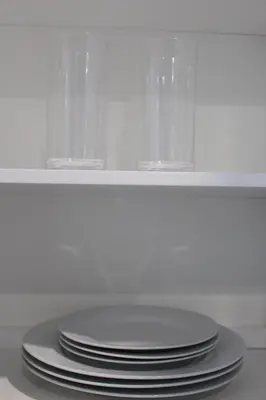 a stack of plates and glasses in a white cabinet at MODERN 1BR GREAT Location Downtown Parking in Albany