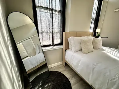 a bedroom with a mirror next to a bed at Private Entrance Cozy Apt Bright Modern in Albany