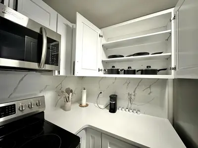 a kitchen with white cabinets and a stove top oven at Private Entrance Cozy Apt Bright Modern in Albany