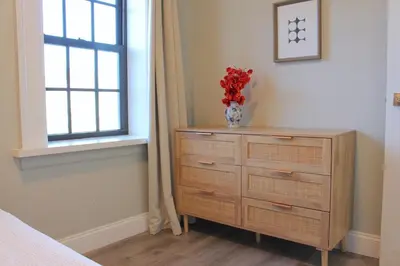 a bedroom with a dresser with a vase of flowers on it at 2 BEDROOM 1 BATH TRENDY Apt Downtown Albany in Albany