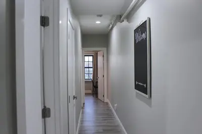 a hallway with white walls and a sign on a wall at 2 BEDROOM 1 BATH TRENDY Apt Downtown Albany in Albany