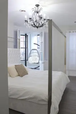 a bedroom with a white bed and a chandelier at Beautiful 2 BED 2 BATH Soaker Tub in Albany