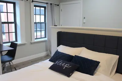 a bedroom with a bed with black and white pillows at UNIQUE Gem in HEART of Albany Spiral Staircase in Albany
