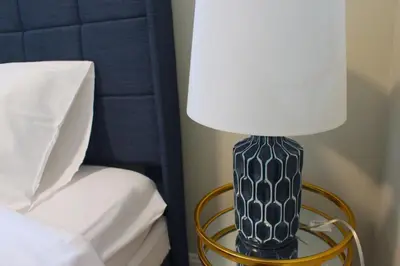 a black and white lamp on a table next to a bed at UNIQUE Gem in HEART of Albany Spiral Staircase in Albany