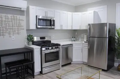 a kitchen with white cabinets and a stainless steel refrigerator at UNIQUE Gem in HEART of Albany Spiral Staircase in Albany