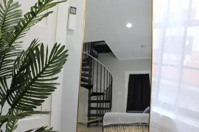 a mirror in a living room with a stair case at UNIQUE Gem in HEART of Albany Spiral Staircase in Albany