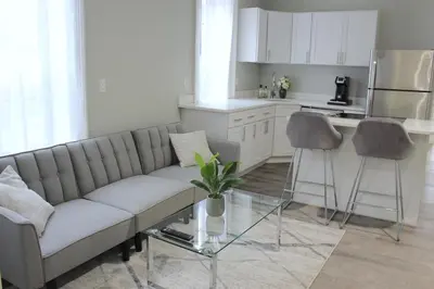 a living room with a couch and two bar stools at WOW Bright Apt PRIME downtown Walk Everywhere in Albany