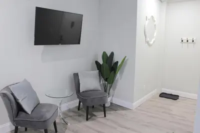 a living room with two chairs and a tv on a wall at WOW Bright Apt PRIME downtown Walk Everywhere in Albany