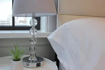 a lamp sitting on a table next to a bed at WOW Bright Apt PRIME downtown Walk Everywhere in Albany