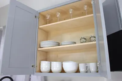 a cupboard with plates and dishes in it at 2 bdrm Modern & Hip Apt with Private Patio in Albany