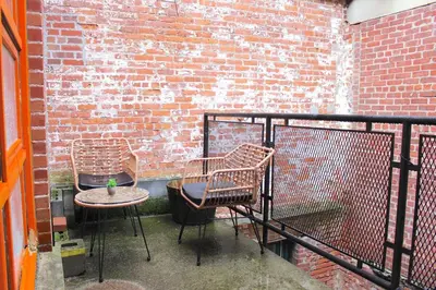 two chairs and a table on a balcony with a brick wall at 2 bdrm Modern & Hip Apt with Private Patio in Albany