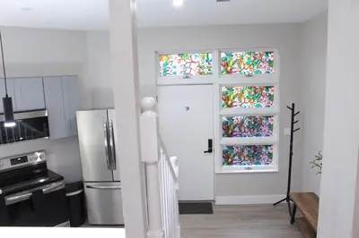 a kitchen with a white door and two windows at 2 bdrm Modern & Hip Apt with Private Patio in Albany