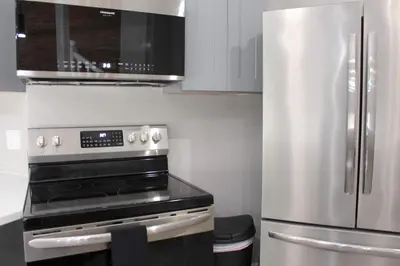 a kitchen with a stove and a stainless steel refrigerator at 2 bdrm Modern & Hip Apt with Private Patio in Albany