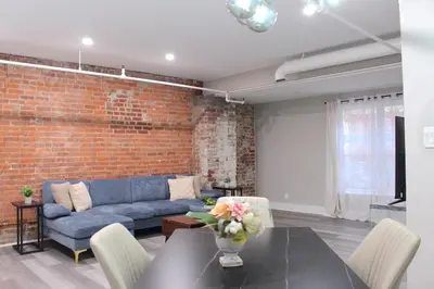 a living room with a blue couch and a brick wall at 2 bdrm Modern & Hip Apt with Private Patio in Albany