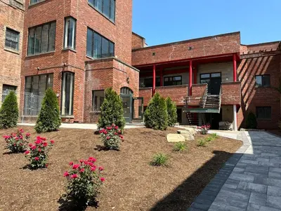 a brick building with flowers in a courtyard at 2 bdrm Modern & Hip Apt with Private Patio in Albany