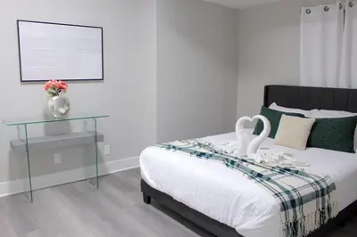 a bedroom with a bed with a glass table with swans on it at 2 bdrm Modern & Hip Apt with Private Patio in Albany