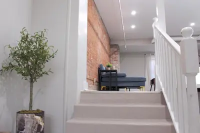 a staircase with a blue chair next to a brick wall at 2 bdrm Modern & Hip Apt with Private Patio in Albany