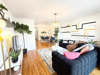 a living room with a large blue couch and a living room with at Luxury 3BR 2BA Retreat NYC Getaway Free Parking in Jersey City
