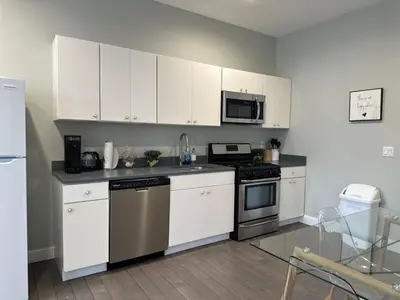 a kitchen with white cabinets and stainless steel appliances at Bright & Airy 1 BDRM Private Apt in Albany