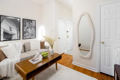 a living room with a couch and a mirror at Cozy 1BD Upper East Side Gem in New York