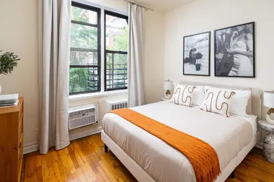 a bedroom with a bed and two windows at Cozy 1BD Upper East Side Gem in New York