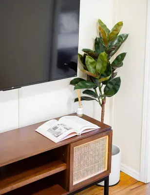 a table with a book and a potted plant on it at Cozy 1BD Upper East Side Gem in New York