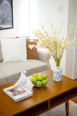 a coffee table with a bowl of fruit and a vase at Cozy 1BD Upper East Side Gem in New York