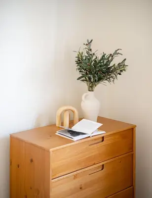 a wooden cabinet with a vase and a plant on it at Cozy 1BD Upper East Side Gem in New York