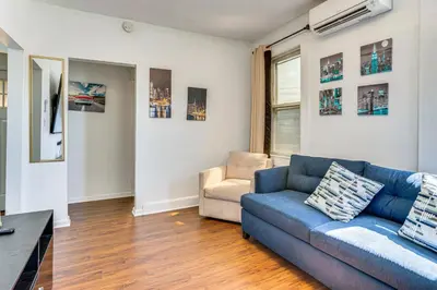 a living room with a blue couch and a chair at Walkable Location Pet-Friendly Apartment in Lodi! in Lodi