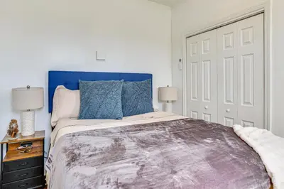 a bed with a blue headboard in a bedroom at Walkable Location Pet-Friendly Apartment in Lodi! in Lodi