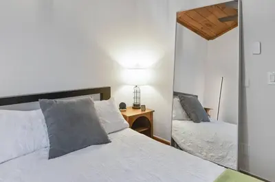 a bedroom with a mirror next to a bed at Lake Zoar Cabin in Newtown