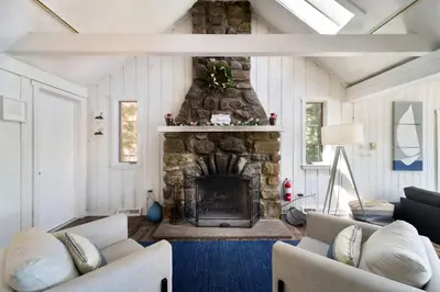 a living room with a stone fireplace with two couches at Dream Lakefront Escape + Beach/Ski/Golf near NYC in Vernon Township