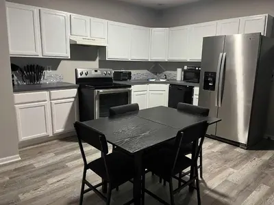 a kitchen with a table and a stainless steel refrigerator at Private Apartment in Southbury 104 in Southbury