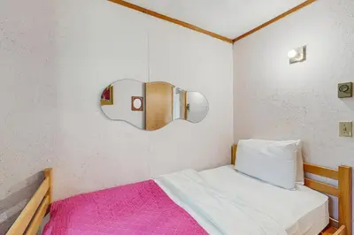 a small bedroom with a bed and a mirror at Ahmeek Retreat in Dover