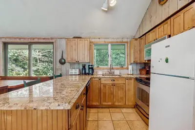 a kitchen with wooden cabinets and a white refrigerator at Ahmeek Retreat in Dover
