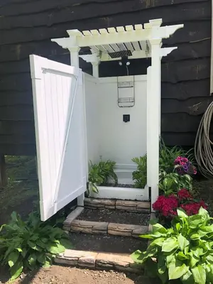 a white door leading into a garden with flowers at Unique and charming, exquisitely themed Log Cabin in Arietta