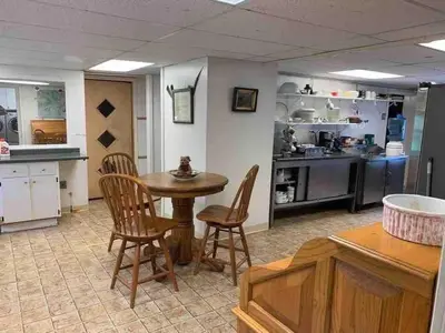 a kitchen and dining room with a table and chairs at Unique and charming, exquisitely themed Log Cabin in Arietta