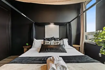 a black bedroom with a bed with black walls at Luxe 1br- Free Parking-King Bed in East Orange