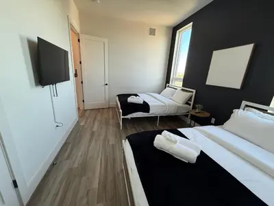 a hotel room with two beds and a tv at NYC View, Free Parking, 2bath in East Orange