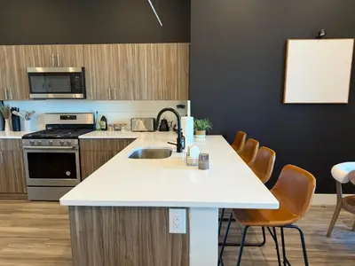 a kitchen with a sink and a counter with chairs at NYC View, Free Parking, 2bath in East Orange