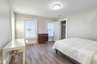 a bedroom with a bed and a desk and windows at Downtown Haven Walk to Yale Renovated Parking in New Haven