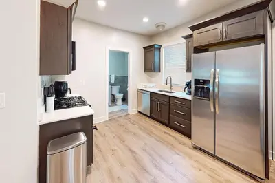 a kitchen with a stainless steel refrigerator and wooden floors at Downtown Haven Walk to Yale Renovated Parking in New Haven