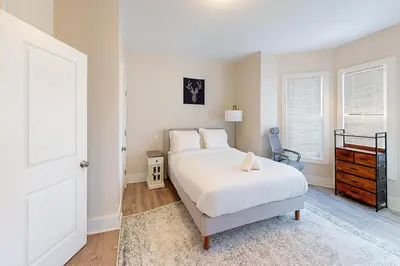 a white bedroom with a bed and a window at Downtown Haven Walk to Yale Renovated Parking in New Haven